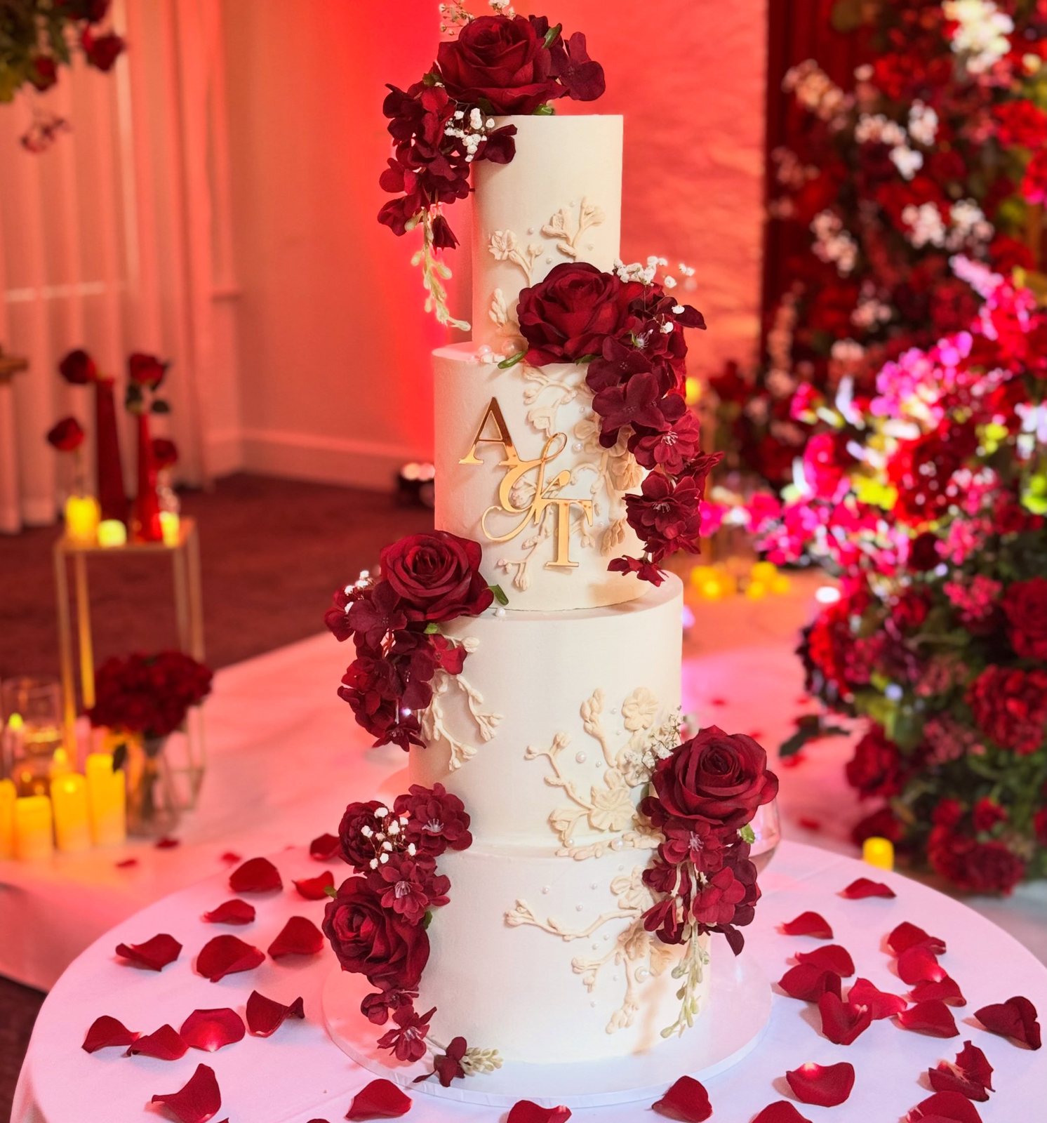 Deep red wedding cake in a candlelit venue