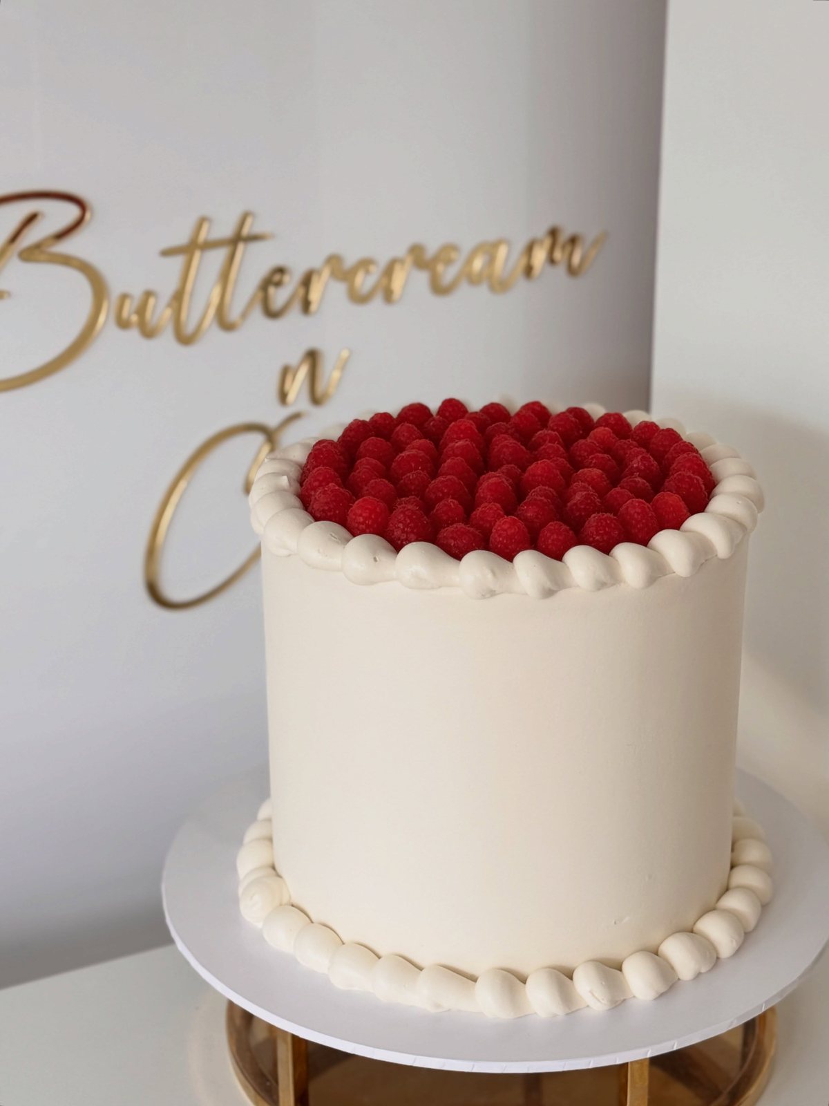White cake crowned with fresh raspberries